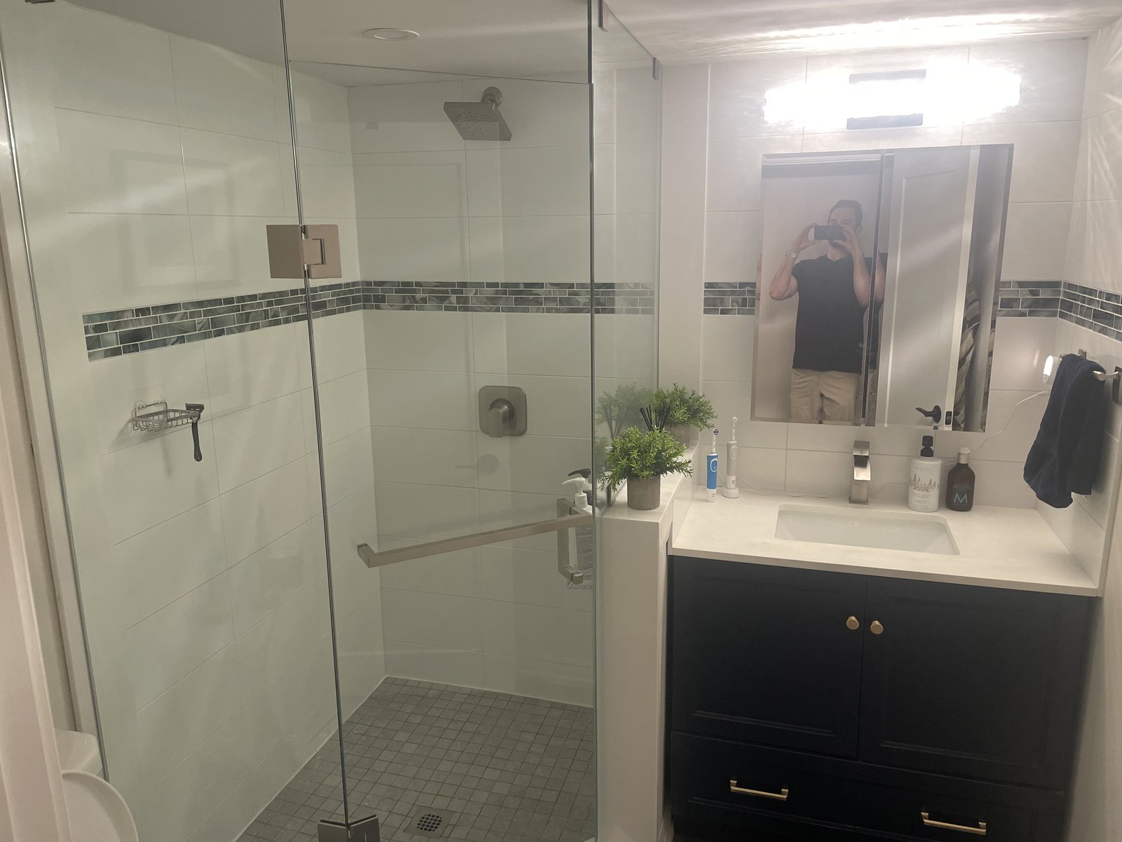 Modern bathroom remodel with glass shower and dark vanity